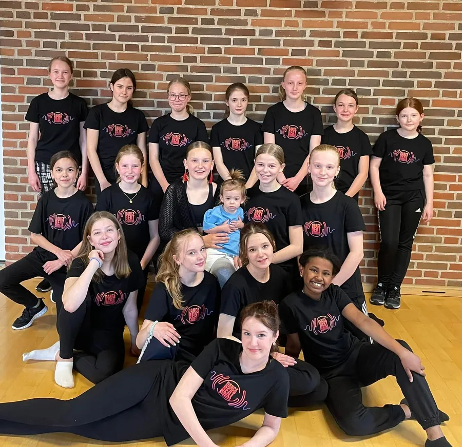 Holdene samlet i Dance Beat Studios-trøjer i gymnastiksalen